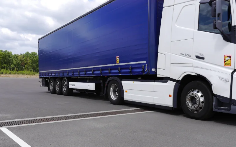LKW auf Straße mit Entwässerungsrinne