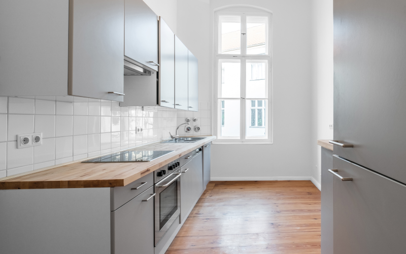 Helle, moderne Einbauküche mit dunklem Holzfussboden