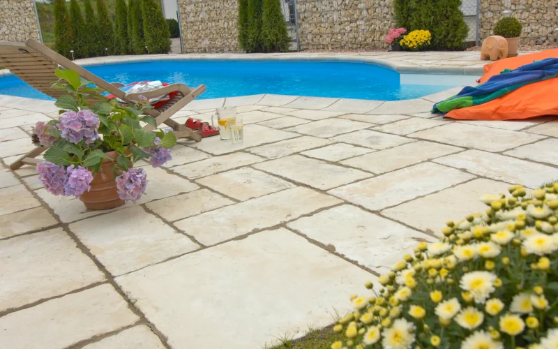 Terrasse mit Pool und Liege auf Sandsteinboden