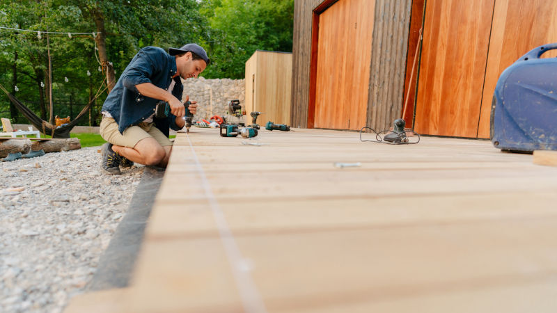 Mann schraubt Terrassendielen fest
