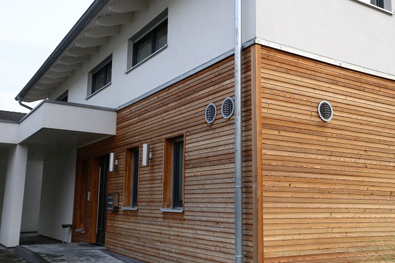 Wohnhaus mit zweigeteilter Fassade aus Putz und Holz