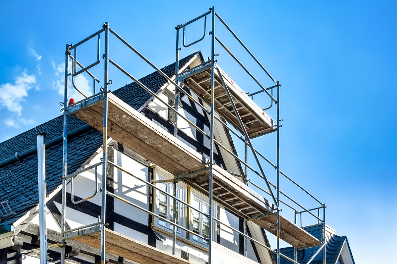 Haus mit Fassade im Bau und einem Gerüst davorstehend