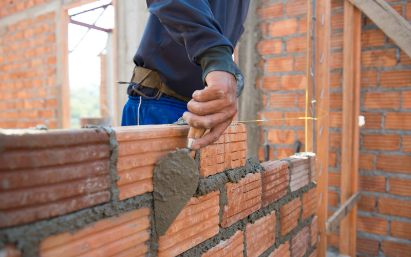 Wand wird von einem Handwerker gemauert