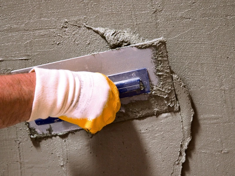 Mörtel wird mit einer entsprechenden Kelle an der Wand verstrichen