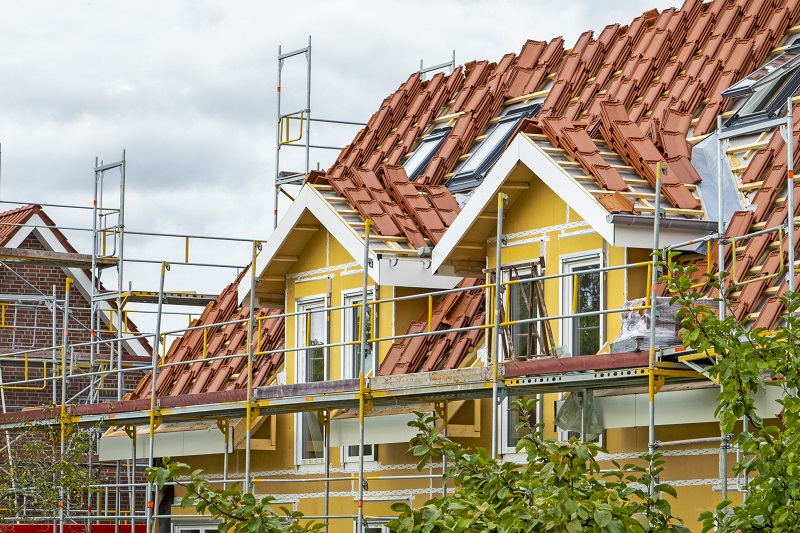 Wohnhaus mit gelber Fassade und Gerüst davor