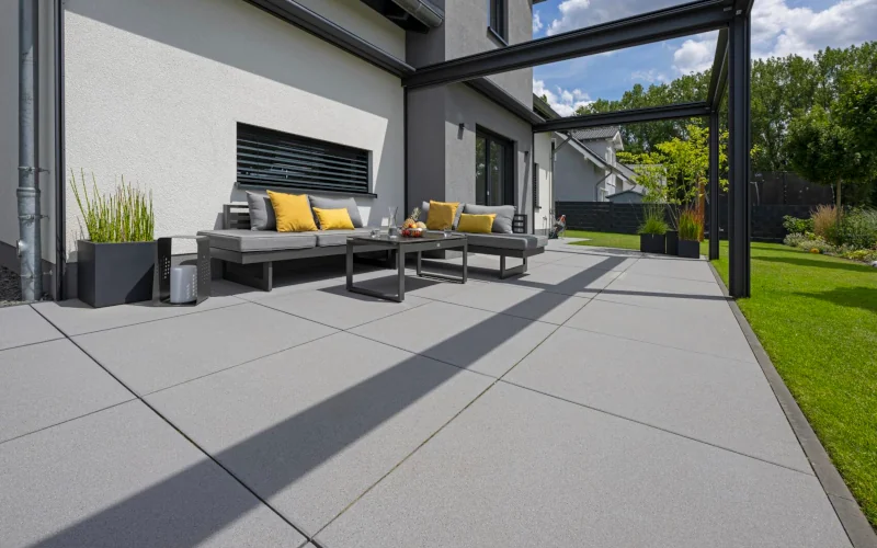 Terrasse mit beton-farbenen großformatigen Platten und Sitzmöbeln