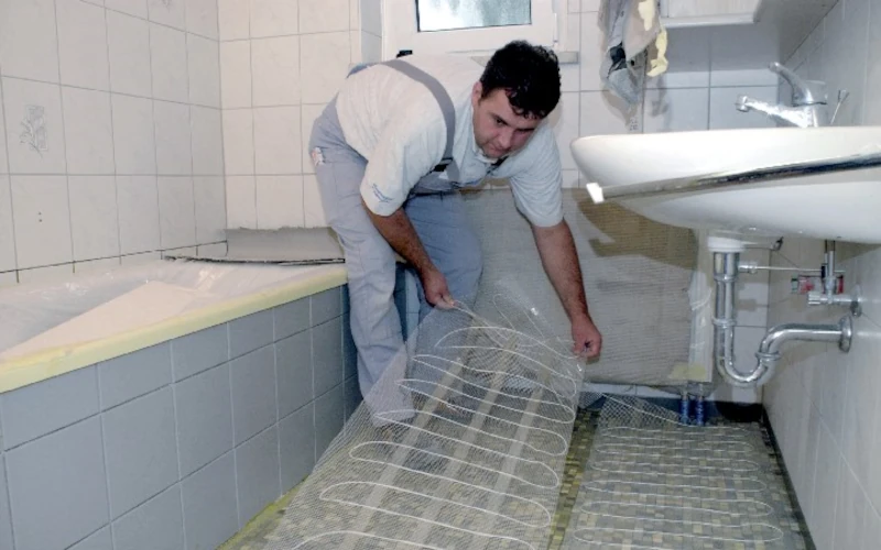 Handwerker verlegt transparenten Untergrund auf dem Boden
