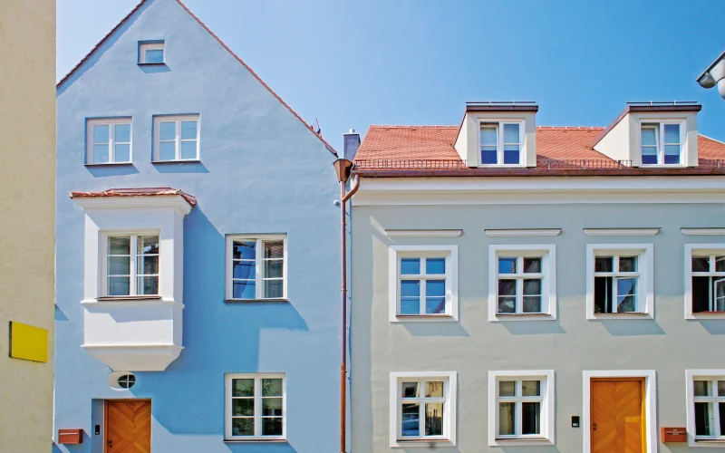 Reihenhaus mit blauer und grauer Fassade und vielen Fenstern
