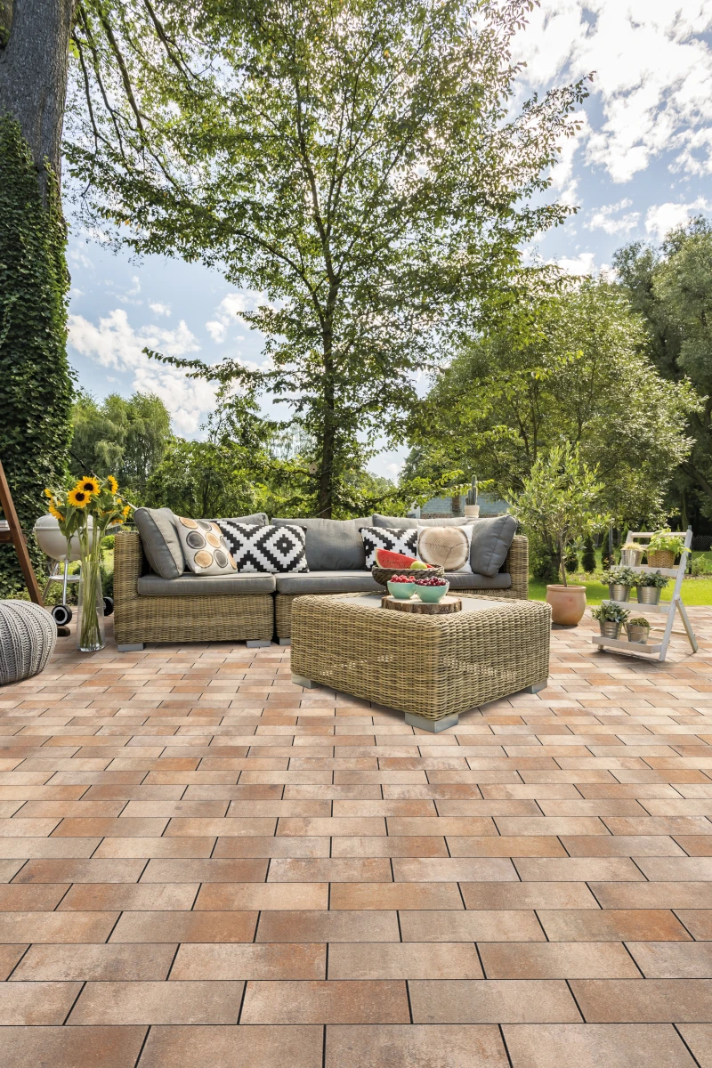 Sitzlounge im Garten auf bräunlichen Terrassenplatten