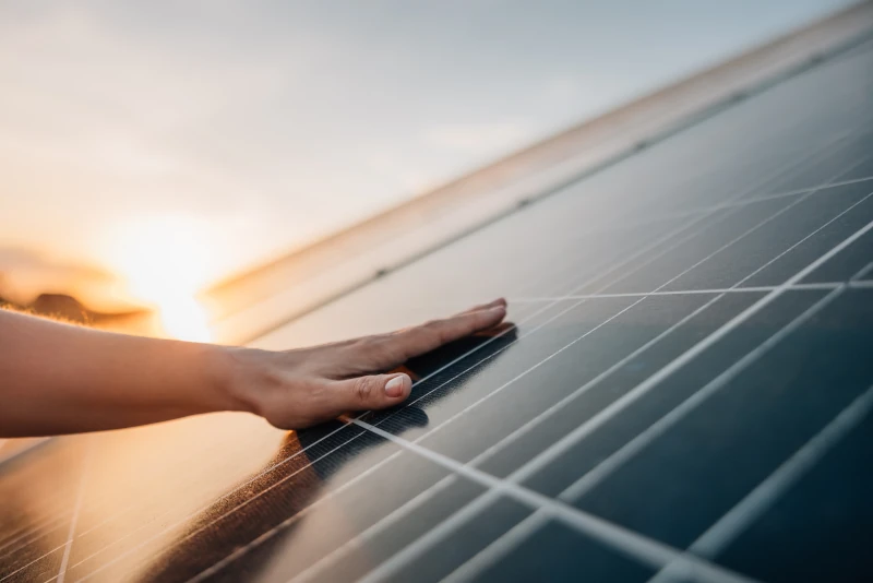Hand liegt auf einem Photovoltaikmodul