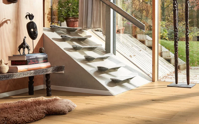 Wohnraum im afrikanischen Stil mit hellem Holzfußboden und einer Steintreppe