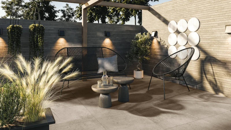 Terrasse mit hellen Platten und Sitzmöbeln