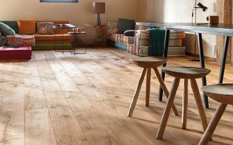 Wohnraum im afrikanischen Stil mit hellem Holzfußboden und vielen Sitzmöbeln