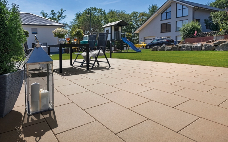 Sonnenterrasse mit Terrassenplatten in Beige der Serie Malibu der Marke Wunderwerk.