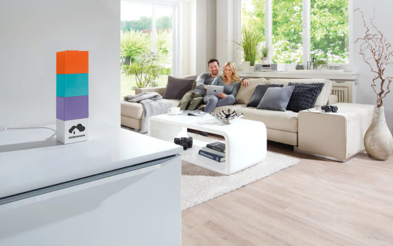 Pärchen sitzt auf einem Sofa in einem großen hellen Wohnraum