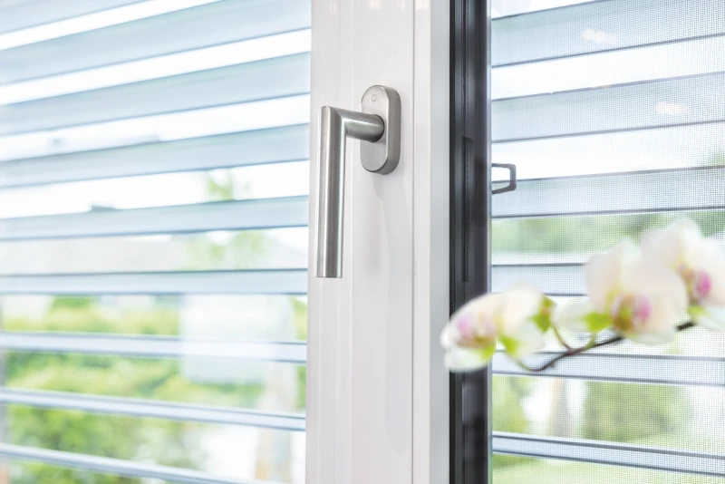 Zu sehen ist ein weißes Fenster mit einem Fenstergriff.