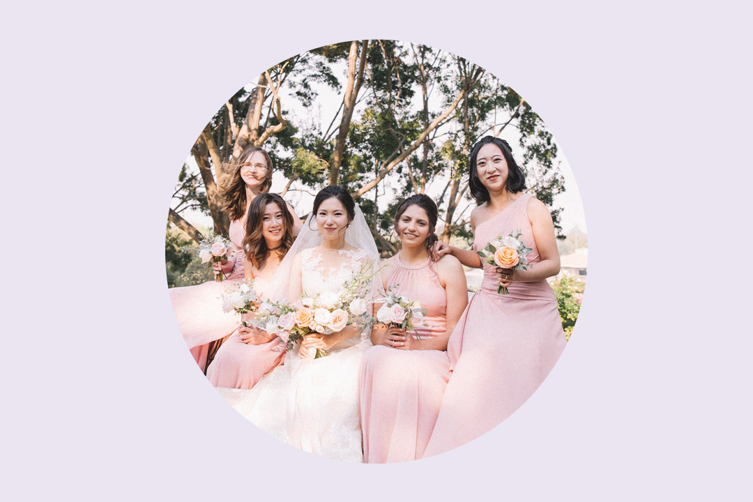Bride sitting with her bridesmaids in pink dresses on the wedding day