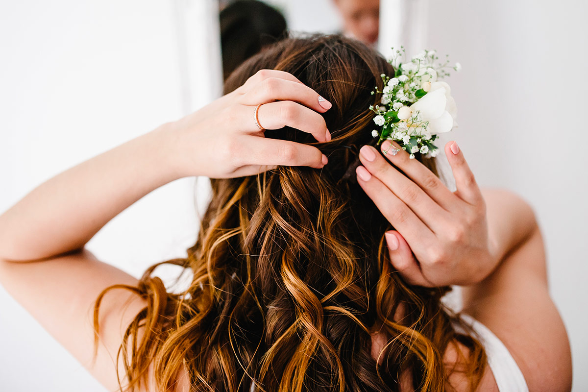 bride adding a flower to her hair