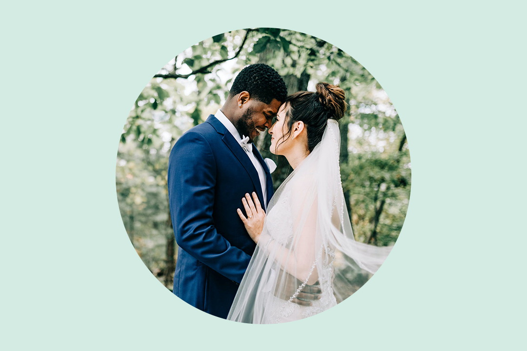 Mixed race bride and groom looking at each other lovingly on their big day