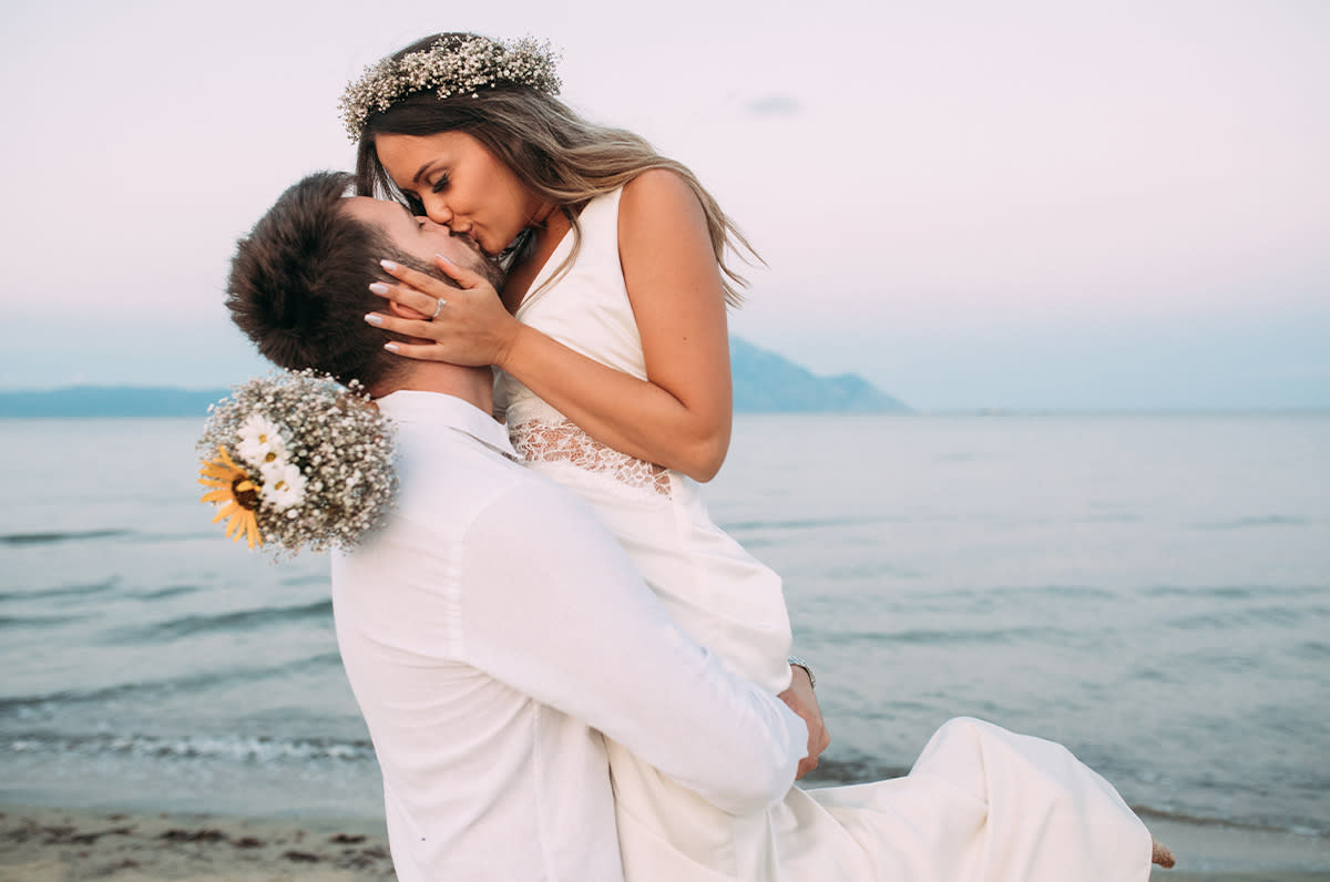 couple kissing on a beach.