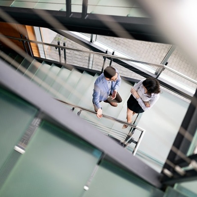 Man and woman standing in a stairwell, viewed from above.