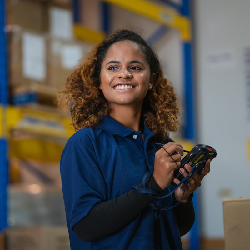 A woman recording or tracking stock in a warehouse or distribution facility.