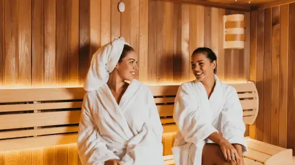 Zwei Frauen sitzen in der Sauna Saunabesuch mit Extensions