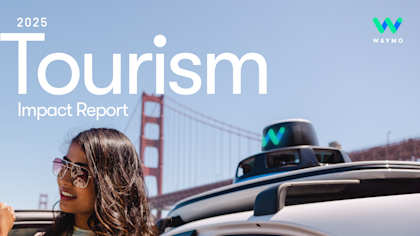 A woman in sunglasses smiles as she exits a Waymo One vehicle, with the Golden Gate Bridge in the background.
