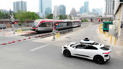 Waymo vehicle in Austin, Texas waiting at a train crossing.