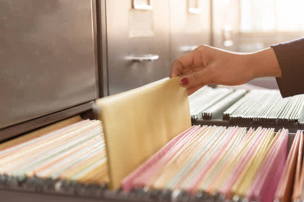 Image of hand pulling a file from a cabinet