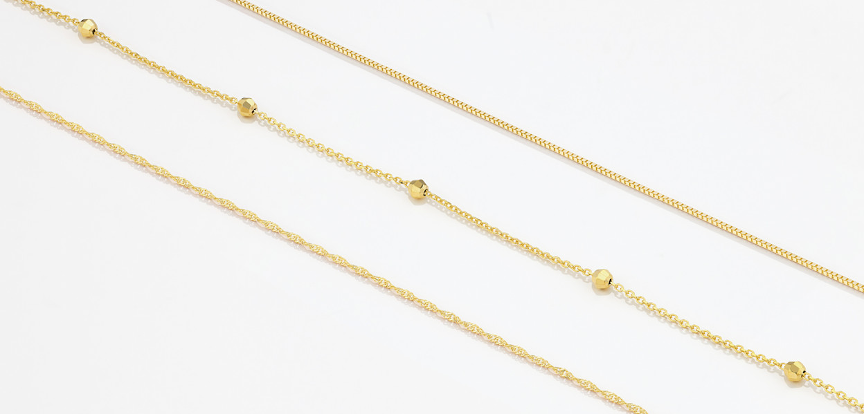 Flatlay of three fine chains