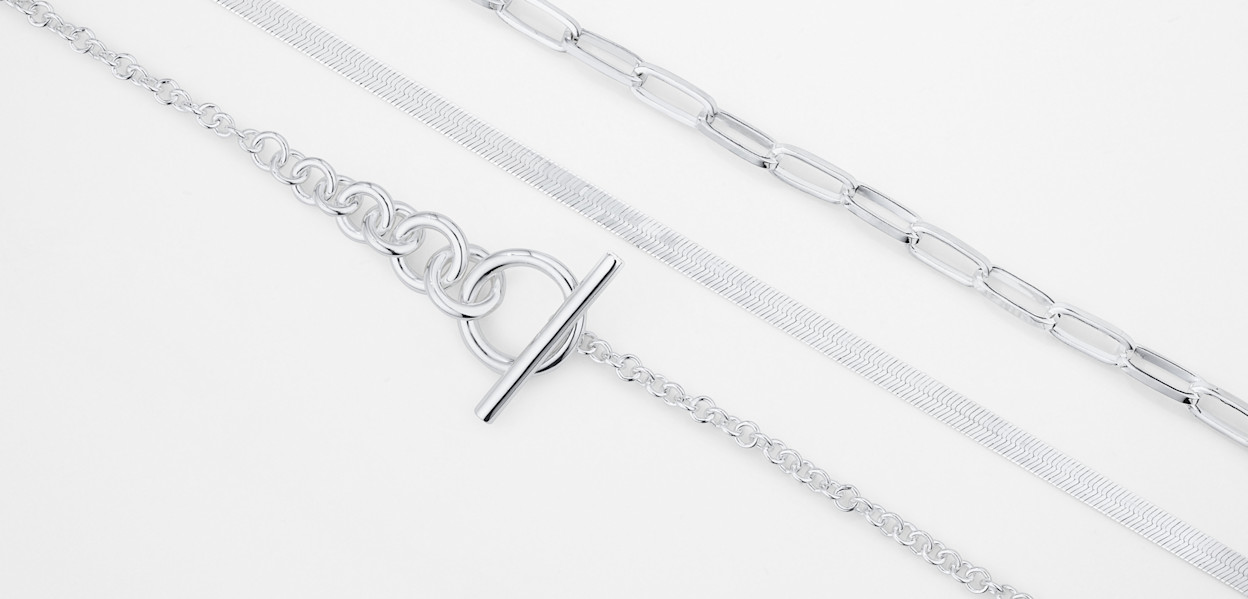 Flatlay of bold silver chains