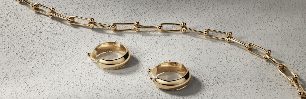 Flatlay of gold hoops and chain