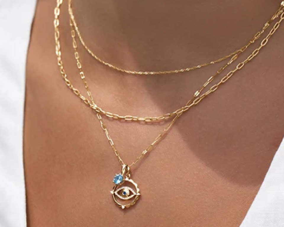 femme portant trois colliers et chaînes superposés