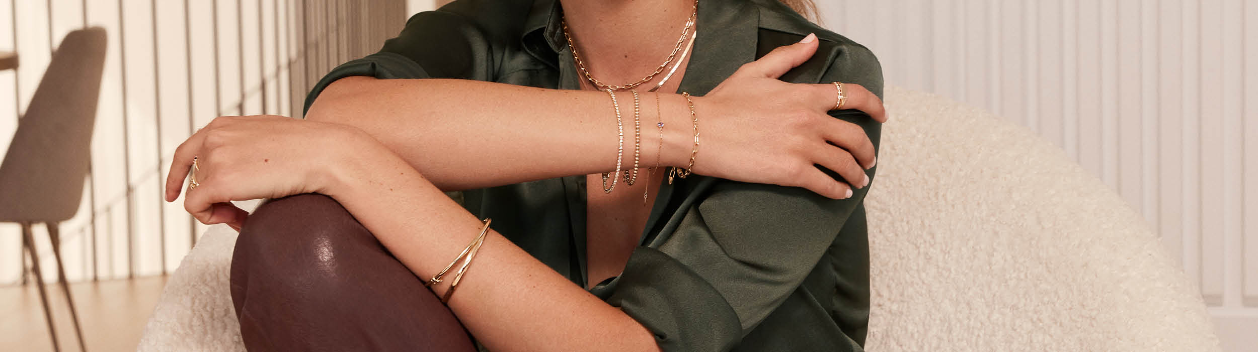 Woman wearing yellow gold necklace and bracelet stack