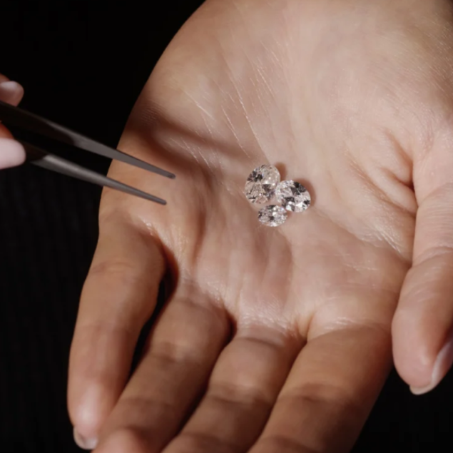 3 large loose diamonds in womans hand