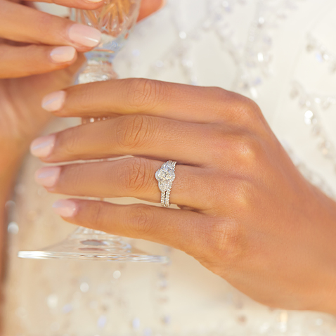 Bride holding glass with diamond engagement ring