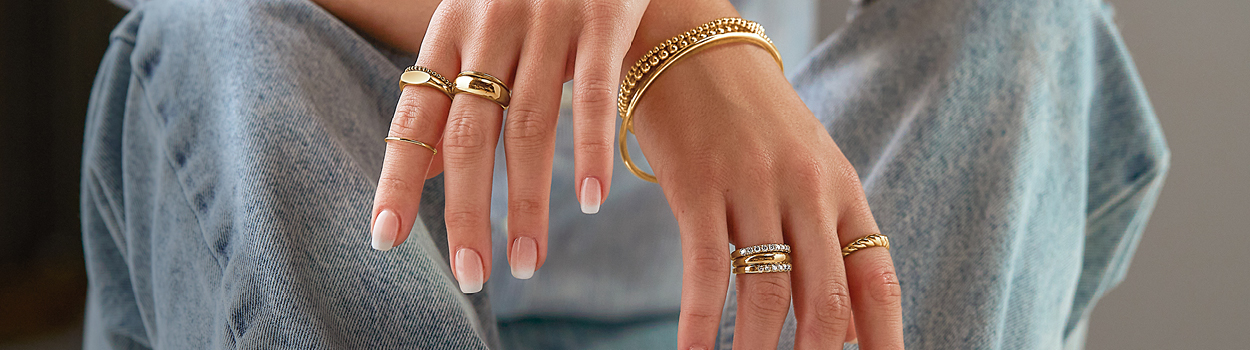 Woman wearing gold ring stacks and bracelets