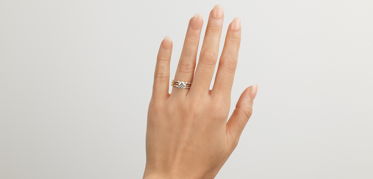 hand wearing engagement and wedding ring