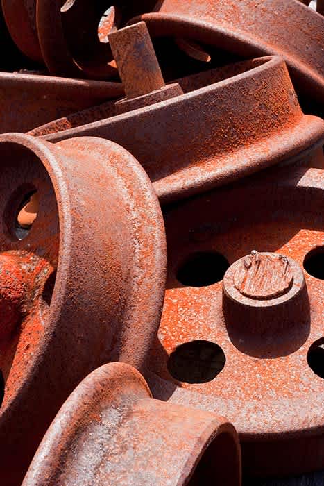 Photograph of pile of old rusty train wheels.