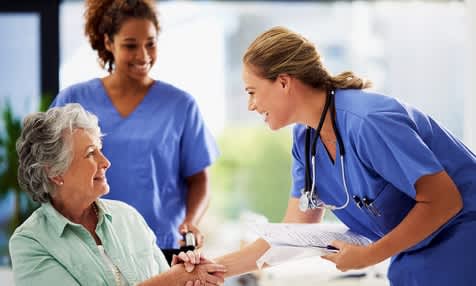 women doctors nurses medical professionals helping elderly woman