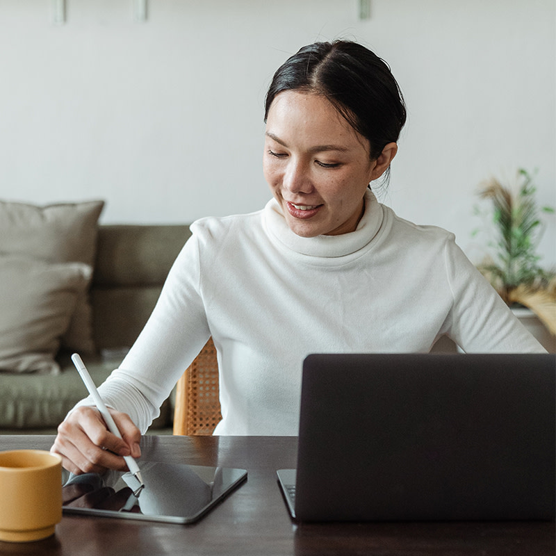 Woman with iPad and laptop