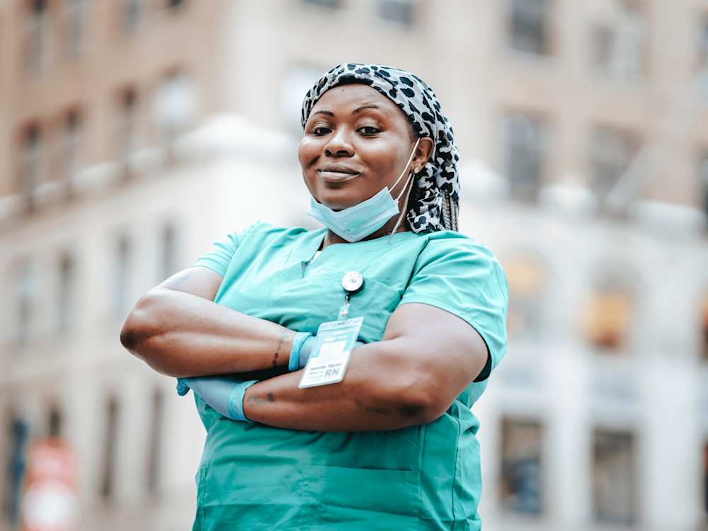 Nurse in scrubs standing in front of a building