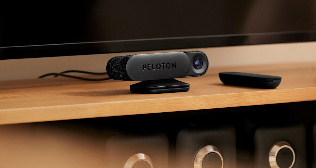 A close up image of the Peloton Guide and remote on a television stand.