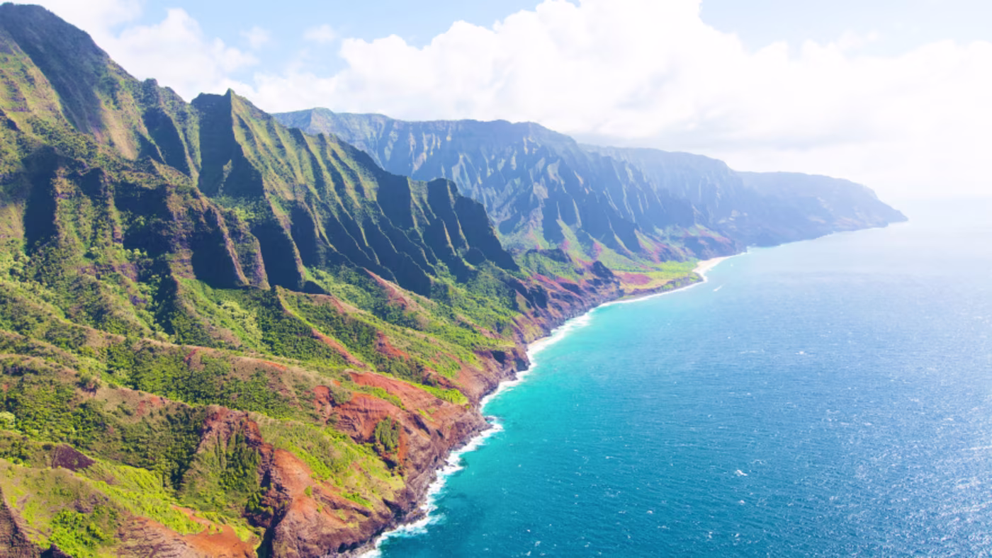 Sunlit mountainous coast of the ocean, aerial view.