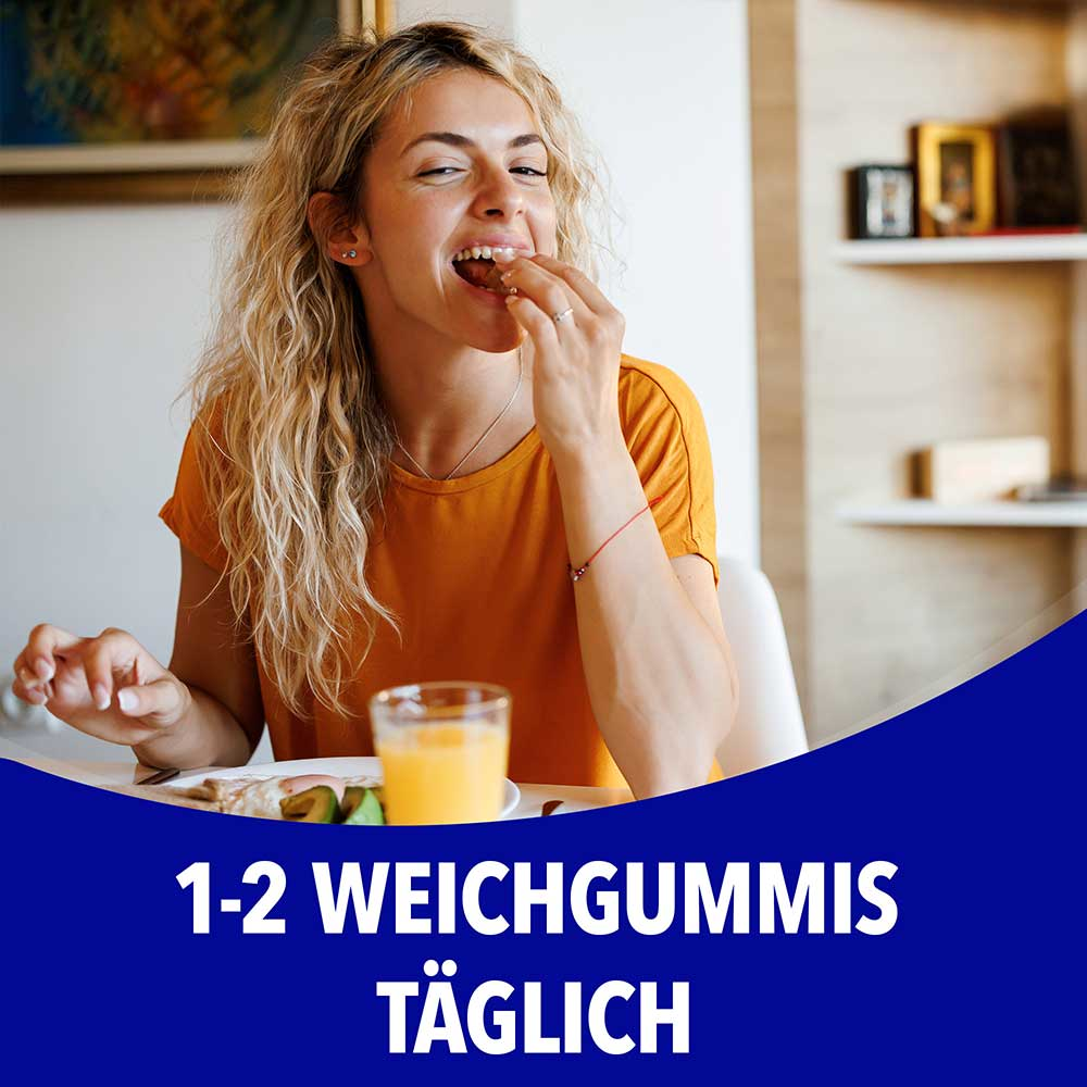 Frau nimmt ein Weichgummi beim Frühstück ein, mit dem Text „1-2 Weichgummis täglich"