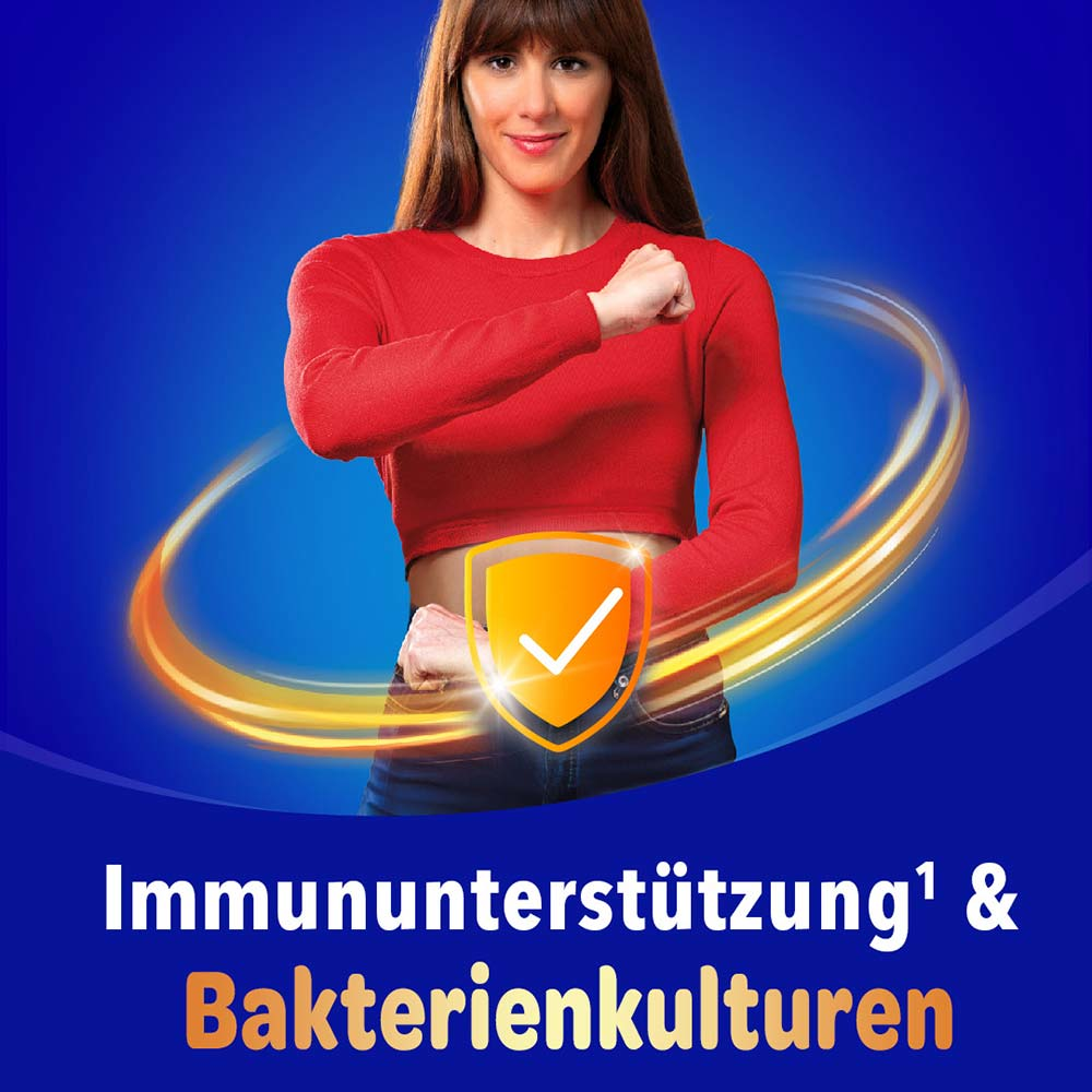 Frau im roten Shirt steht selbstbewusst mit verschränkten Armen und einem goldenen Schutzschild-Icon mit dem Text „Immununterstützung & Bakterienkulturen"