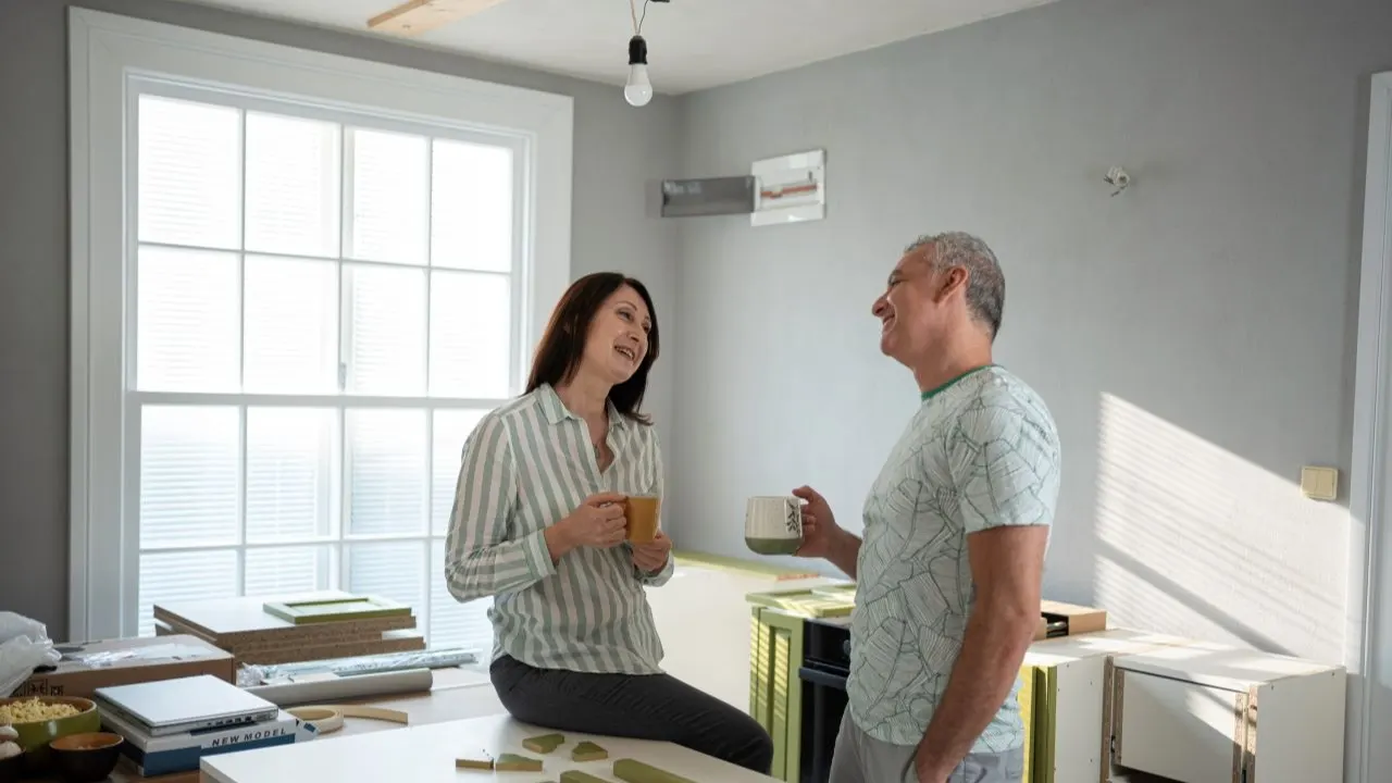 Middle-aged couple enjoying coffee while planning a home renovation, representing homeowners using a home equity loan (HEL) without the need for private mortgage insurance (PMI).