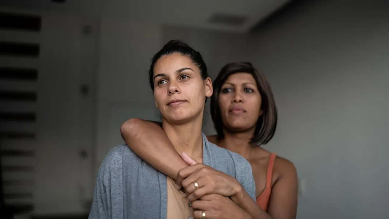 Contemplative lesbian couple at home