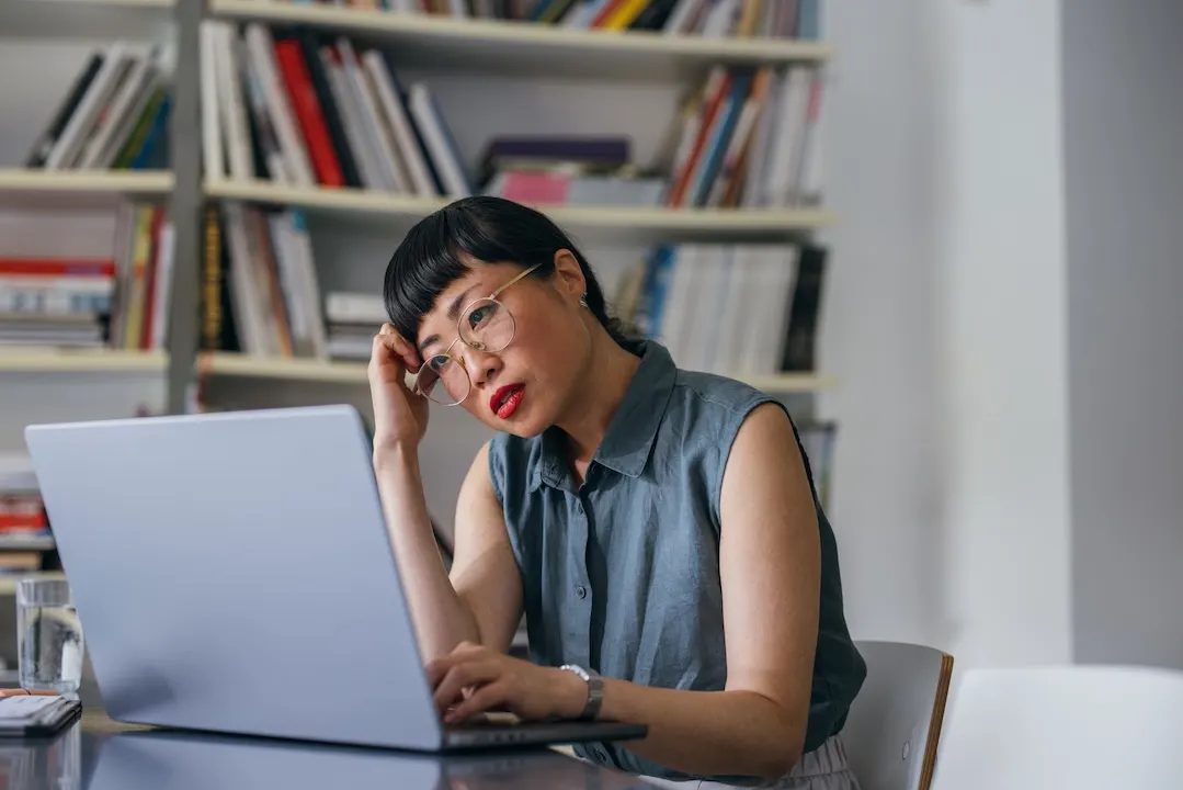 Woman looks frustrated while sitting at desk.